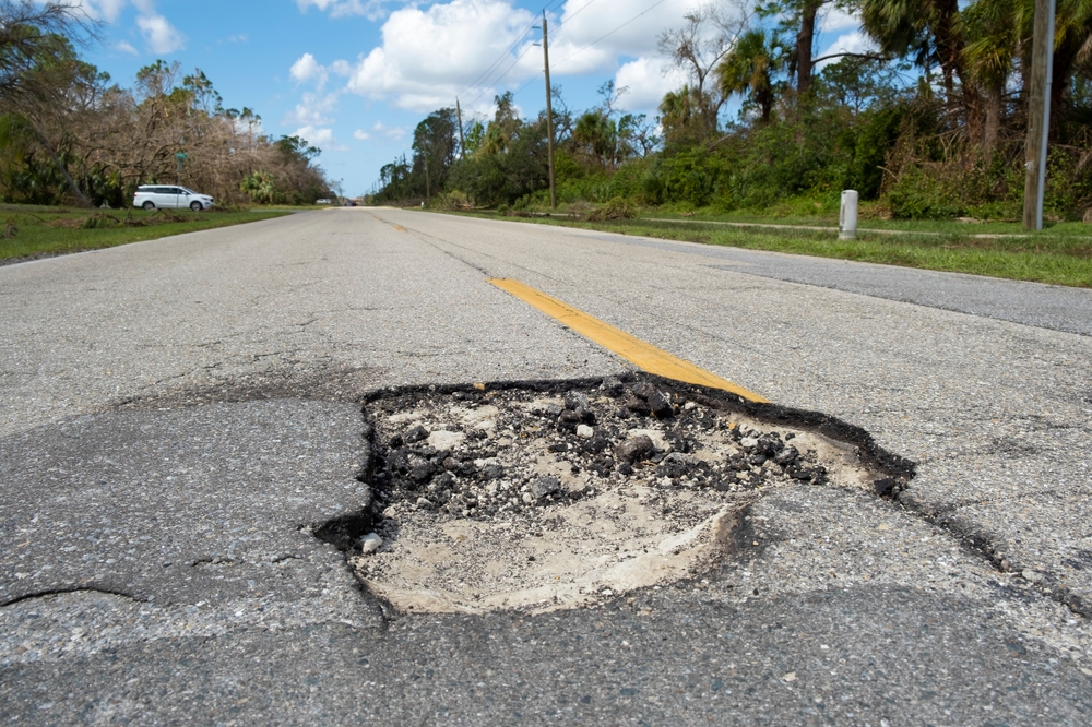 Damaged,american,road,surface,with,deep,pothole.,ruined,street,in